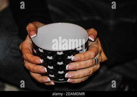 Zwei Hände halten einen Becher Stockfoto