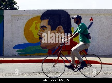 Guacara, Carabobo, Venezuela. November 2020. 13. November 2020. Ein Mann passiert vor dem Graffiti von Nicolas Maduro, Präsident von Venezuela, als er mit dem Fahrrad fährt. In Guacara, Carabobo, Venezuela . Foto: Juan Carlos Hernandez Kredit: Juan Carlos Hernandez/ZUMA Wire/Alamy Live News Stockfoto