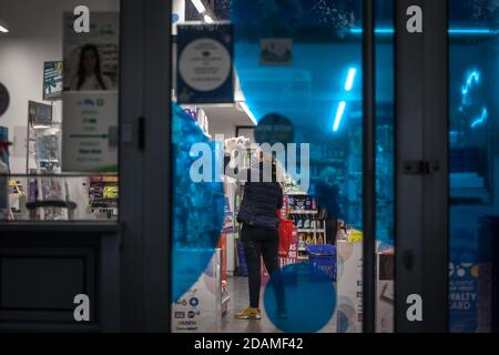 BELGRAD, SERBIEN - 10. OKTOBER 2020: Frau, Angestellte einer Apotheke, hält Produkte mit Gesichtsmaske Schutzausrüstung auf Coronavir Stockfoto