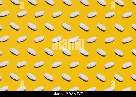 Verschiedene pharmazeutische weiße Medizin Pillen, Tabletten und Kapseln auf hellem gelben Hintergrund. Medizin kreative Konzepte. Flache Lay-Ansicht von oben Stockfoto