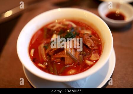 Schüssel mit Lagman auf dem Tisch im Restaurant Stockfoto