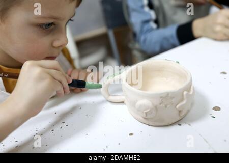 Junge Malerei Tonkrug in Töpferei Stockfoto