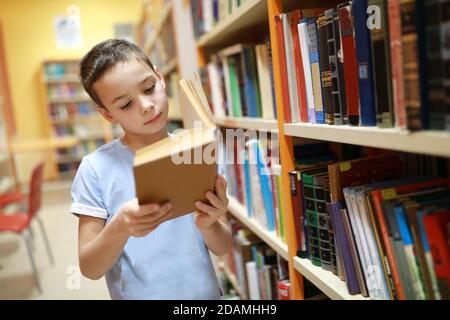 Porträt des Kindes Auswahl Buch in der Bibliothek Stockfoto