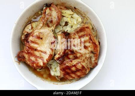 Gebackene Schweinelende mit Zwiebeln auf dem Teller Stockfoto