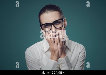 Frustrierte Geschäftsfrau mit Kopf in den Händen, sie ist gestresst und überlastet Stockfoto