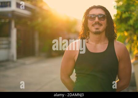 Schöner Mann mit lockigen Haaren und Schnurrbart auf den Straßen Im Freien Stockfoto