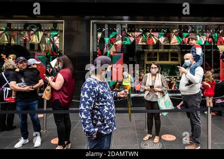 Ein Mann trägt eine Gesichtsmaske trägt einen Papagei beim Gehen auf der Straße, Melbourne nach mehreren Tagen keine neuen Covid-19 Fällen ist immer bereit für eine Covid normale Weihnachten. Stockfoto