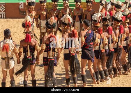 Eine Gruppe von Naga Tribesmen in ihrer traditionellen Kleidung gekleidet tanzen während des Hornbill Festivals in Nagaland Indien am 4. Dezember 2016 Stockfoto