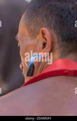 Abstract Porträt eines Naga-Tribesmanns mit blauer Feder Traditioneller Ohrring in Kisama Nagaland Indien am 4. Dezember 2016 Stockfoto