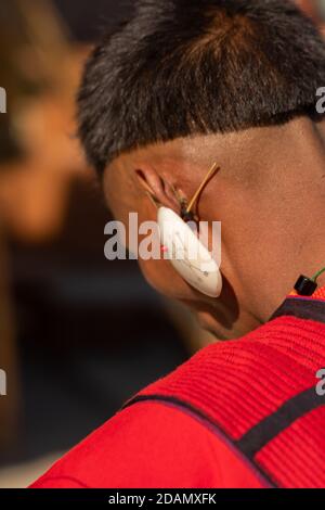 Abstract Porträt eines Naga-Stammesmannes in seinem Stammesangehörigen Kleidung trägt einen großen weißen traditionellen Ohrring im Kisama Nagaland Indien am 4. Dezember 2016 Stockfoto