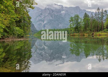 Wandern entlang der Ufer des Almsees mit den Bergen Der Totesgebrige im Hintergrund Stockfoto