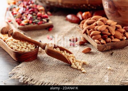 Pinienkerne und getrocknete Früchte auf einem alten Holztisch. Selektiver Fokus. Stockfoto