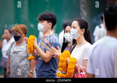 Asiatische Thailänder beten den Buddha im Guan Yin Thien Fah Schrein mit Blumen, Weihrauch und großen Kerzen an. Chinesische Tempel ist eine berühmte touristische destina Stockfoto