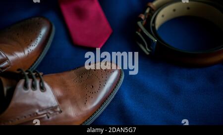 Nahaufnahme der männlichen Hochzeit Bräutigam Accessoires Set.Mode-Stil Braune Lederschuhe und Gürtel und Krawatte blauen Marine Anzug Stockfoto