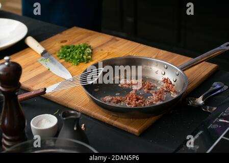 Speck in einer Pfanne auf einem Holzbrett Stockfoto