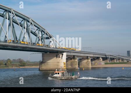 Niederländischer Personenzug, der eine blaue Brücke in Nijmegen, Gelderland passiert Stockfoto