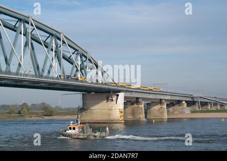 Niederländischer Personenzug, der eine blaue Brücke in Nijmegen, Gelderland passiert Stockfoto