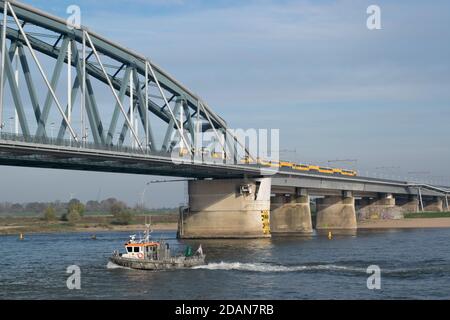 Niederländischer Personenzug, der eine blaue Brücke in Nijmegen, Gelderland passiert Stockfoto