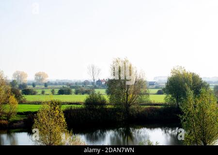 Altes holländisches Haus, das vor einem kleinen Fluss in einer holländischen Polderlandschaft steht, typische holländische Naturszene, fotografiert während des Herbstes Stockfoto