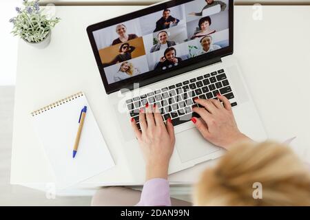 Bild der jungen Studentin, die Teilnahme an Online-Vortrag auf Laptop am Schreibtisch beschnitten Stockfoto