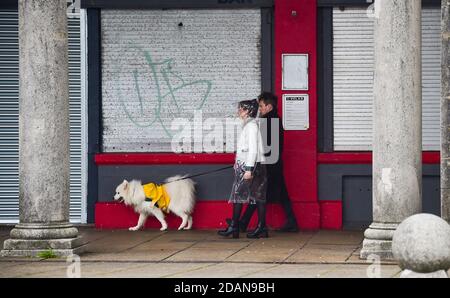 Brighton UK 14. November 2020 - Wanderer decken sich entlang der Küste von Brighton an einem nassen und windigen Tag entlang der Südküste : Credit Simon Dack / Alamy Live News Stockfoto