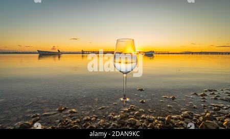 Spiegelung im Glas bei Sonnenuntergang am Strand. Stockfoto