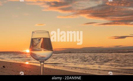 Spiegelung im Glas bei Sonnenuntergang am Strand. Stockfoto