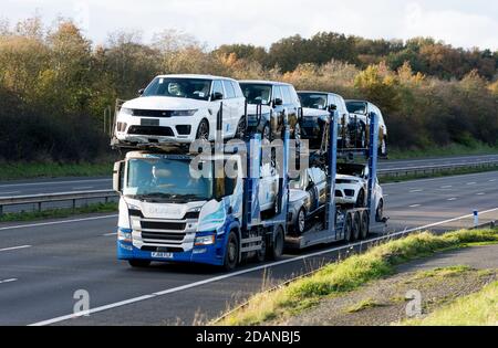 Ein Transporter für mobile Dienste mit neuen Land Rover Fahrzeugen auf der Autobahn M40, Warwickshire, Großbritannien Stockfoto