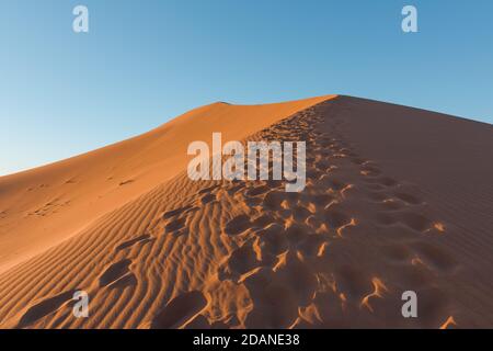 Weitwinkel schießen von Fußweg in Wüstendünen von Erg Chigaga.die Tore der Sahara, bei Sonnenaufgang. Marokko. Konzept von Reisen und Abenteuer Stockfoto