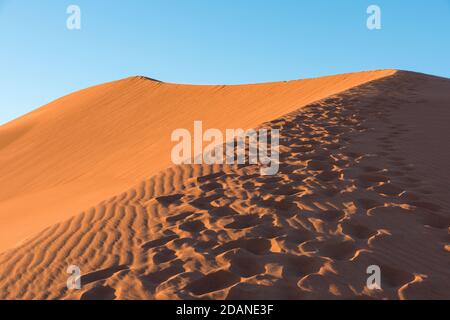 Weitwinkel schießen von Fußweg in Wüstendünen von Erg Chigaga.die Tore der Sahara, bei Sonnenaufgang. Marokko. Konzept von Reisen und Abenteuer Stockfoto