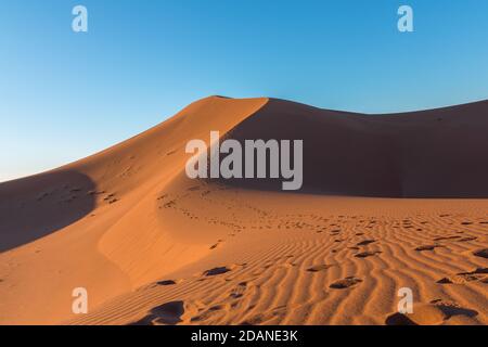 Weitwinkel schießen von Fußweg in Wüstendünen von Erg Chigaga.die Tore der Sahara, bei Sonnenaufgang. Marokko. Konzept von Reisen und Abenteuer Stockfoto