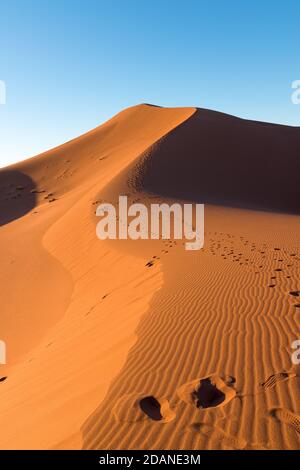 Weitwinkel schießen von Fußweg in Wüstendünen von Erg Chigaga.die Tore der Sahara, bei Sonnenaufgang. Marokko. Konzept von Reisen und Abenteuer Stockfoto