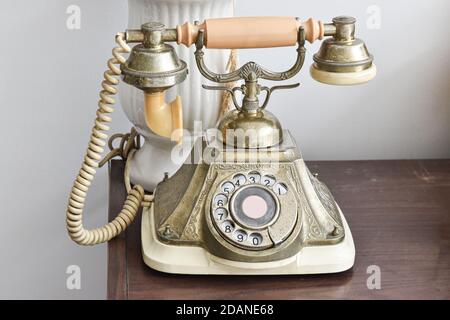 Vintage-Telefon auf Holztisch Hintergrund. Antikes Drehtelefon. Stockfoto
