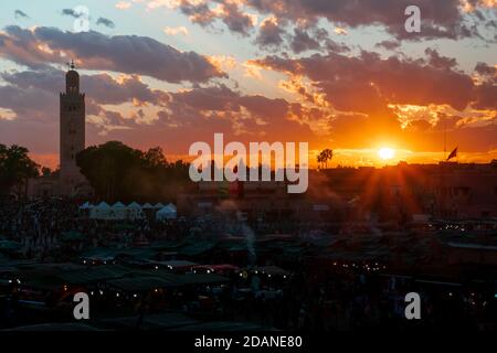 Yamaa el Fna Platz mit seinen Märkten und Menschenmassen und der Turm der Moschee im Hintergrund, bei Sonnenuntergang. Reisekonzept. Marrakesch, Marokko Stockfoto