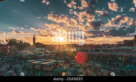 Yamaa el Fna Platz mit seinen Märkten und Menschenmassen und der Turm der Moschee im Hintergrund, bei Sonnenuntergang. Reisekonzept. Marrakesch, Marokko Stockfoto