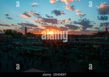 Yamaa el Fna Platz mit seinen Märkten und Menschenmassen und der Turm der Moschee im Hintergrund, bei Sonnenuntergang. Reisekonzept. Marrakesch, Marokko Stockfoto