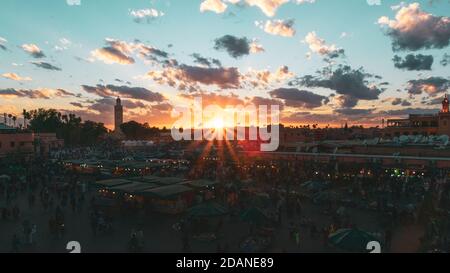 Yamaa el Fna Platz mit seinen Märkten und Menschenmassen und der Turm der Moschee im Hintergrund, bei Sonnenuntergang. Reisekonzept. Marrakesch, Marokko Stockfoto