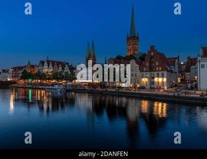 Lübecker Altstadt bei Dämmerung. Die Kirche mit zwei Türmen ist Marienkirche - St. Mary's Church, St. Petri Kirche - St. Peter's hat einen einzigen Turm. Stockfoto