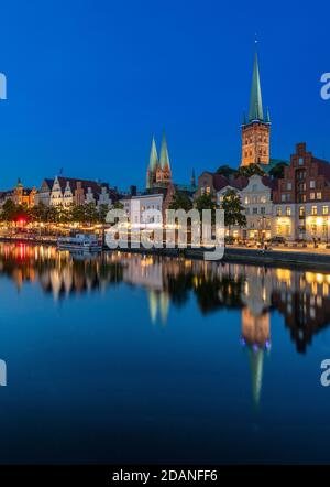 Lübecker Altstadt bei Dämmerung. Die Kirche mit zwei Türmen ist Marienkirche - St. Mary's Church, St. Petri Kirche - St. Peter's hat einen einzigen Turm. Stockfoto