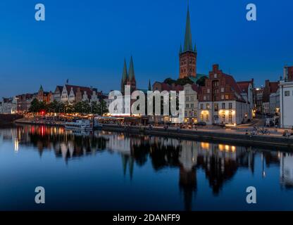 Lübecker Altstadt bei Dämmerung. Die Kirche mit zwei Türmen ist Marienkirche - St. Mary's Church, St. Petri Kirche - St. Peter's hat einen einzigen Turm. Stockfoto