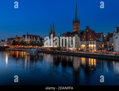 Lübecker Altstadt bei Dämmerung. Die Kirche mit zwei Türmen ist Marienkirche - St. Mary's Church, St. Petri Kirche - St. Peter's hat einen einzigen Turm. Stockfoto