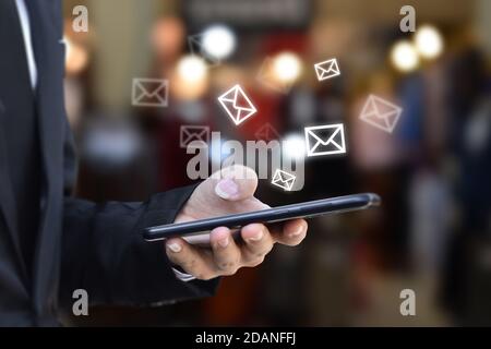 Hand halten mit Mobiltelefon mit E-Mail-Symbol auf dem Bildschirm. Konzept der Business Communication Technology. Stockfoto