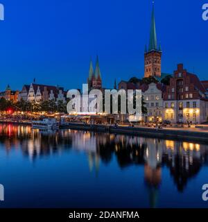 Lübecker Altstadt bei Dämmerung. Die Kirche mit zwei Türmen ist Marienkirche - St. Mary's Church, St. Petri Kirche - St. Peter's hat einen einzigen Turm. Stockfoto