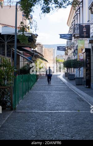 Athen, Griechenland - 10. November 2020. COVID19 Coronavirus-Sperre. Mann, der in einer leeren Straße im Stadtzentrum, Plaka historischen touristischen Bereich zu Fuß Stockfoto