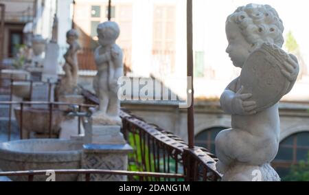 Detail eines antiken Kreuzgangs in einem Kloster in Palermo, Italien. Kleine Marmorbrunnen mit einer Statue eines Kindes Stockfoto