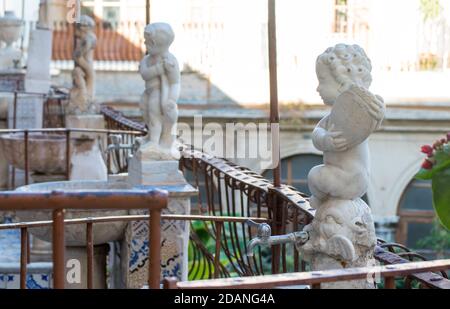 Detail eines antiken Kreuzgangs in einem Kloster in Palermo, Italien. Kleine Marmorbrunnen mit einer Statue eines Kindes Stockfoto