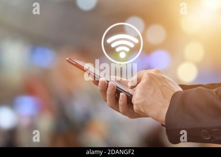 Nahaufnahme der männlichen Hände mit dem mobilen Smartphone mit WiFi-Symbol. Technologie und soziale Netzwerke Konzept Stockfoto