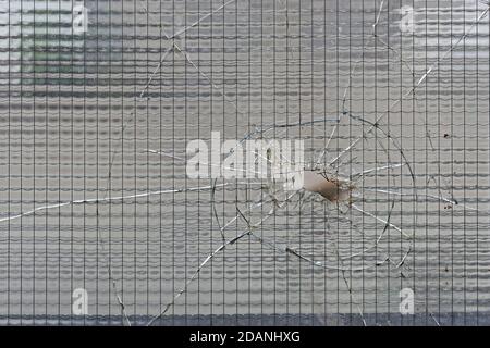 Zerbrochenes Sicherheitsglas mit großer Lochbeschädigung Stockfoto