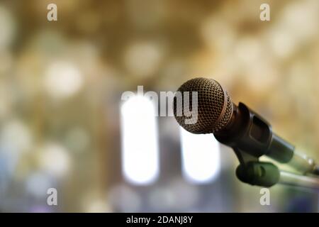 Nahaufnahme des Mikrofons auf der Bühne vor einem Bokeh-Hintergrund. Stockfoto