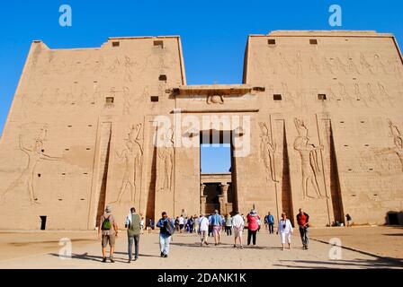 Assuan Ägypten. Touristen am Eingang des Tempels von Horus, Sky God in Edfu. Westufer des Nils, Oberägypten. Stockfoto